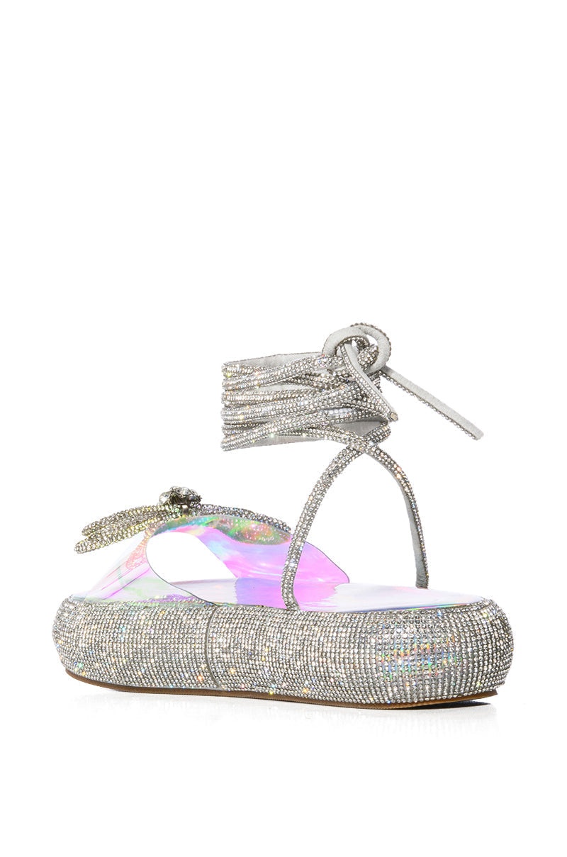 OUTSHINE EMBELLISHED BOW LACE UP FLAT SANDAL IN HOLO